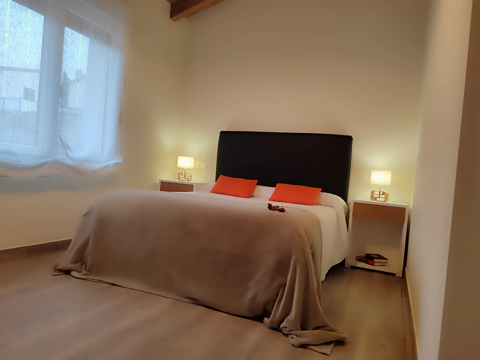 Habitación doble con almohadas naranjas en Ispilu Etxea