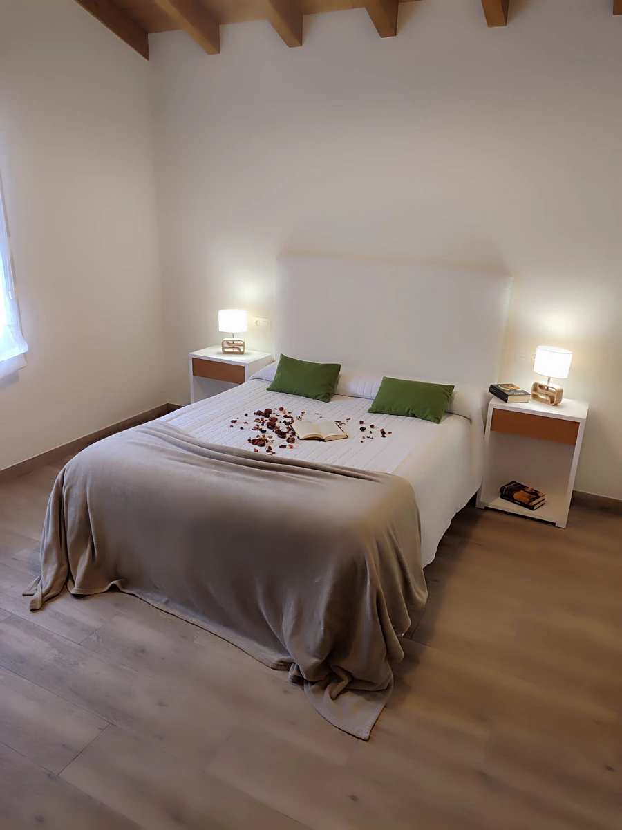 Habitación con cama doble y almohadas verdes